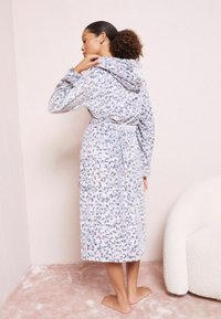 Mīksts peldmētelis ar kapuci, ar gaismas pelēku leoparda rakstu zila un rozā toņos, ar jostu viduklī un līdz ceļiem.