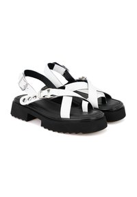 Witte leren sandalen met banden en een stevige zwarte rubberen zool, met kruisbaanen en verstelbare gespen voor een veilige pasvorm.