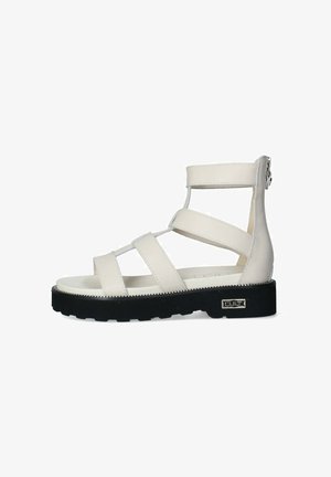 Sandal in pelle bianca con tre fasce larghe e zip sul retro. Presenta una suola spessa in gomma nera con un bordo testurizzato e dettaglio del logo.