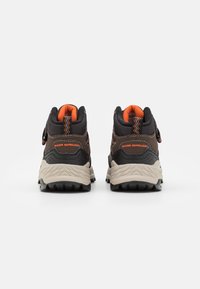 Zapatos de senderismo repelentes al agua con un upper en gris oscuro, acentos naranjas, suela texturizada y correa ajustable. Incluye un collar acolchado.