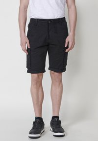 Shorts cargo noirs avec revers, en tissu de coton mélangé. Comprend plusieurs poches et une taille élastique avec cordon de serrage.
