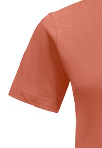 Koraalkleurig T-shirt met korte mouwen, gemaakt van zachte stof, met een ronde halslijn, een iets getailleerde pasvorm en een zachte textuur.