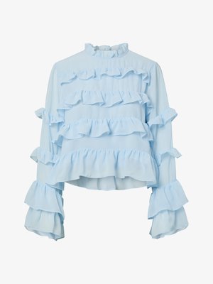 Ljusblå blus med volanger på kroppen och ärmarna, hög hals och långa ärmar, tillverkad av ett lätt material.
