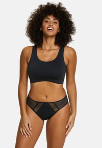Brassière noire extensible avec des bretelles larges et un slip assorti, dotés d'accents en dentelle et en mesh à l'avant. Texture lisse, design simple.