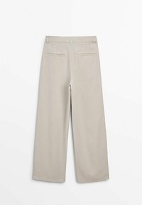 Beige wide-leg trousers with a smooth texture, featuring a high waistband and two back pockets. No visible hardware or patterns.