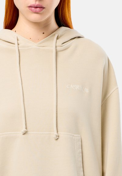 Hoodie beige en tissu doux avec une poche kangourou, des cordons de serrage à la capuche et un logo "CAMPER LAB" brodé à l'avant.