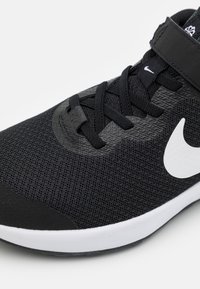 Melna sporta kurpe ar sieta tekstūru, ar melniem šņorēm un lielu baltu Swoosh logotipu. Zole ir balta ar melnu akcentu gar malām.