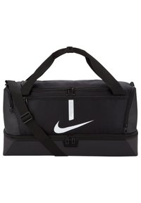 Zwarte Nike sporttas met dubbele ritssluitingen, verstelbare schouderriem en prominent wit logo aan de voorkant. Duurzame stofconstructie.