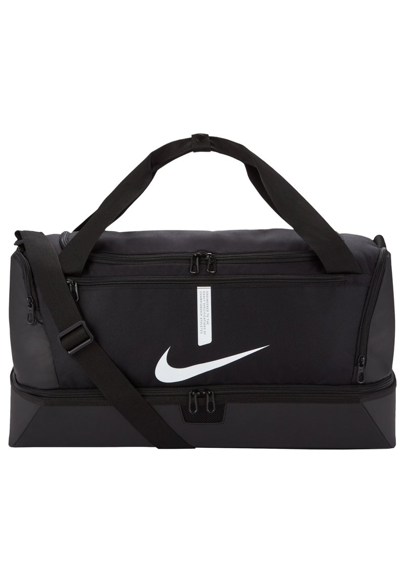 Zwarte Nike sporttas met dubbele ritssluitingen, verstelbare schouderriem en prominent wit logo aan de voorkant. Duurzame stofconstructie.