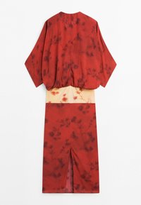 Back view of a red and beige floral kimono with wide sleeves and a slit at the back of the skirt.