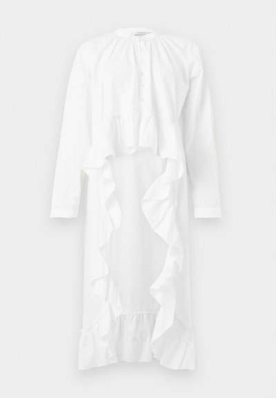 Λευκό φόρεμα μακρυμάνικο με κουμπωτό ντεκολτέ και καταρράκτη βολάν από τη μέση ως το τελείωμα, με σχέδιο υψηλό-χαμηλό.