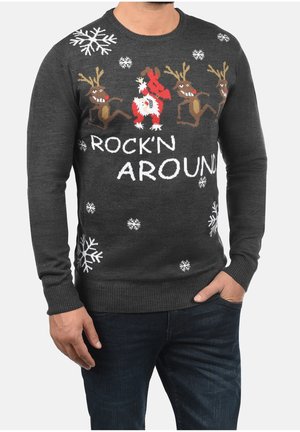 Pull de Noël gris foncé avec des rennes dansants, un Père Noël jouant de la guitare rouge, des flocons de neige blancs et le texte "ROCK'N AROUND".