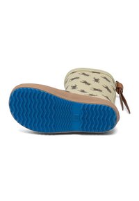 Botte de pluie beige pour enfant avec motifs de scarabées marron, semelle bleue texturée et sangle marron sur le côté.