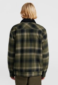 Groen en zwart geruit flanellen shirt met een contrasterende kraag, voorzien van een rechte snit en twee met knopen sluitende manchetten. Zachte textuur.