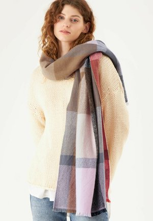 Überprüfter Schal in Beigetönen, Grau und Rosé; gewebte Textur mit fransigen Kanten, über einem leichten Strickpullover drapiert.