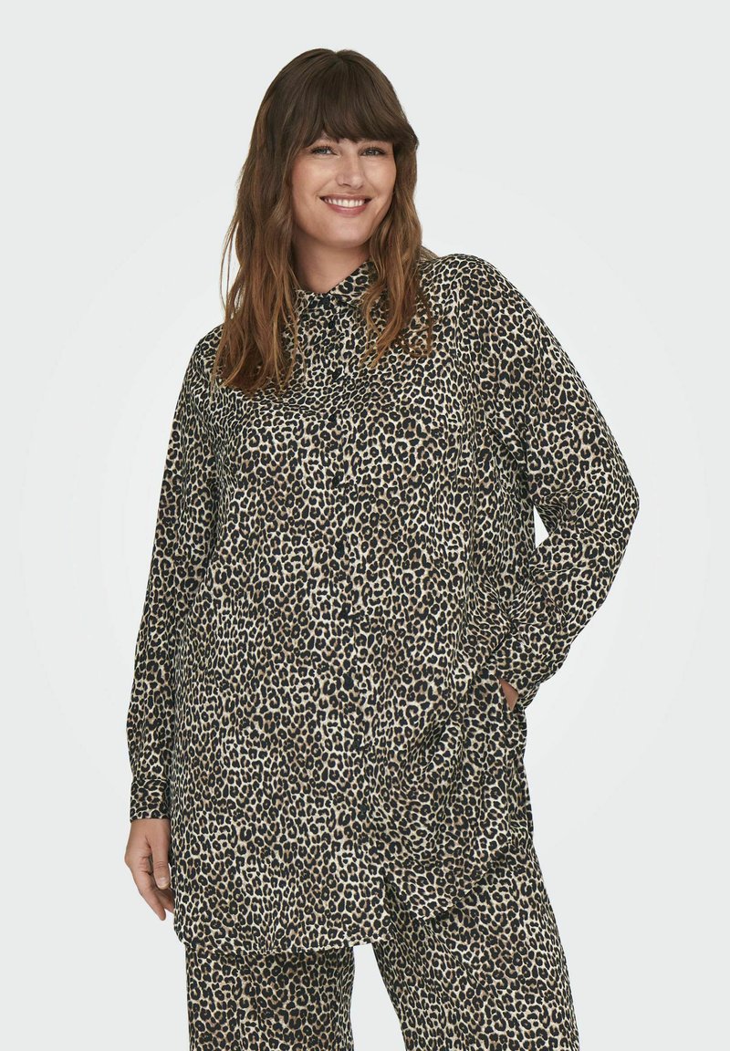 Leopardų rašto mygtukų š shirtas su ilgomis rankovėmis, pagamintas iš minkštos medžiagos; turi apykaklę ir kišenes, derinamas su atitinkančiomis kelnėmis.