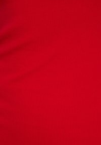 Tissu côtelé rouge avec une texture lisse, présentant des lignes verticales sur toute sa surface. La surface est uniforme et vive en couleur.