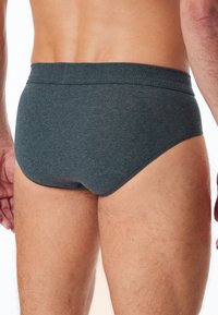 Graue Baumwollunterhose mit einem glatten, enganliegenden Design, einem weichen Bund und nahtlosen Kanten, die einen einfachen, klassischen Stil betonen.