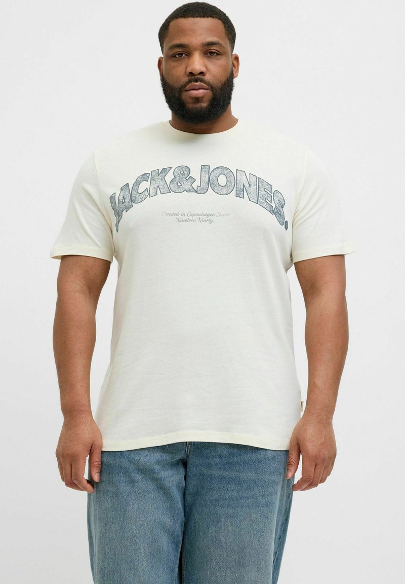 Světle žluté bavlněné tričko s modrým potiskem "JACK&JONES", krátké rukávy, kulatý výstřih a volný střih. Modré džíny dotvářejí vzhled.