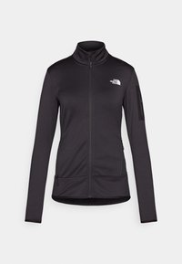 Black, long-sleeve zip-up jacket made of soft, stretchy fabric. Features a high collar, two front pockets, and a logo on the chest.