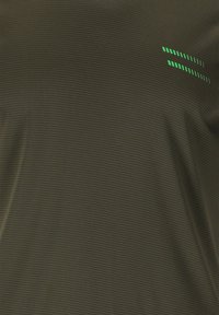 Dunkelolivgrünes, strukturiertes Hemd mit einem Rautenmuster. Verfügt über reflektierende grüne Akzente in Form von Streifen auf der oberen linken Seite.