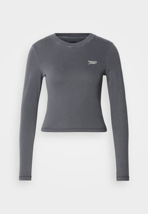 Pelēks garām piedurknēm tops, izgatavots no elastīga auduma; tam ir apaļš dekoltē un mazs balts "tommy jeans" logotips uz krūšu.