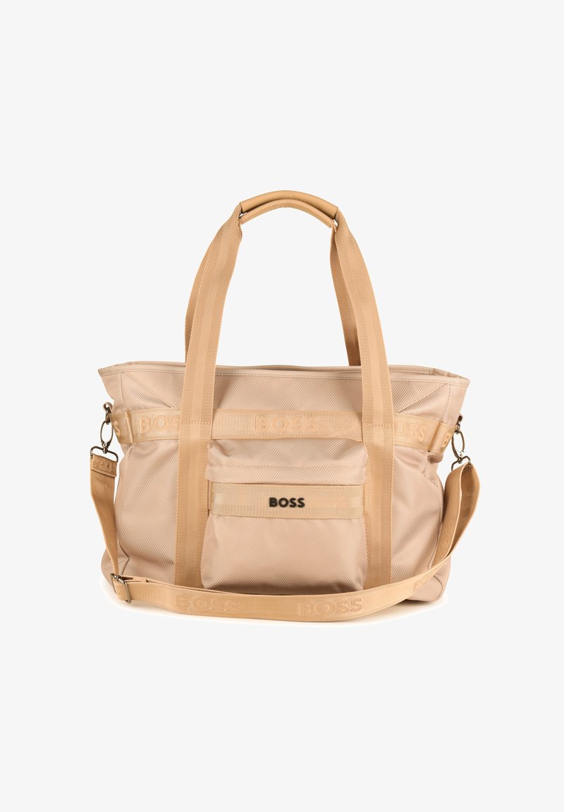Sac fourre-tout en nylon beige avec deux poignées, une bandoulière réglable, une poche avant et des détails de logo. Texture lisse et forme structurée.