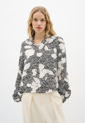 Black and white patterned blouse with a v-neck, long sleeves, and gathered cuffs. Made of lightweight fabric with an abstract floral design.