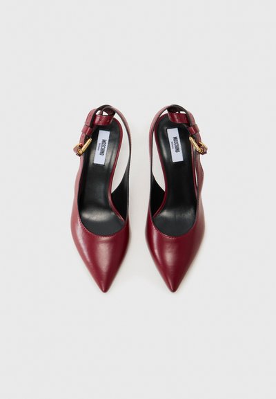 Burgundy leather slingback heels with pointed toes, featuring a slim ankle strap and gold-tone hardware. Smooth texture with minimal design.