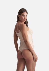 Body color pelle con spalline regolabili, design aderente e texture liscia, che offre un aspetto seamlessly sul retro.