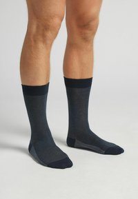 Calcetines de marine ribeteados con patrón texturizado, puntera y talón reforzados, acentos en gris contrastante, longitud a medio pantorrilla, fabricados en material suave.