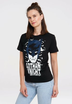 Black cotton t-shirt featuring a graphic print of a stylized batman face surrounded by bats, with "GOTHAM KNIGHT" text in white.