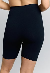 Pantaloni corti neri a coste con vita alta, lunghezza fino a metà coscia, texture liscia e senza chiusure o motivi visibili.