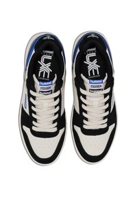 Baskets athlétiques blanches et noires avec des accents bleus, présentant des textures en cuir et en suède, un bout rond, des perforations et des lacets plats.