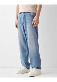 Ljust blå denimjeans med en avslappnad passform, med fem fickor och kontrasterande sömmar. Bärs med vita sneakers.