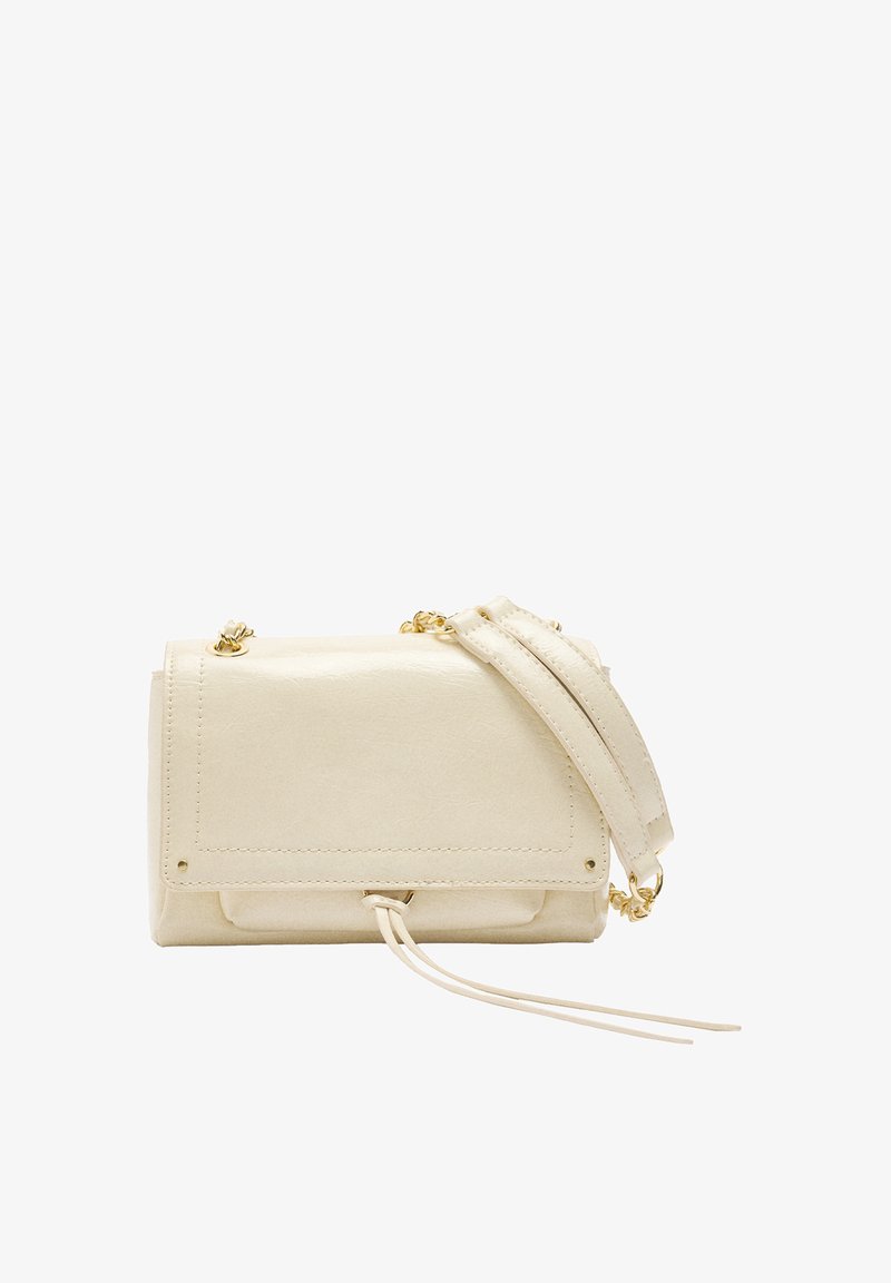 Kremowa skórzana torebka na ramię z klapą, złotym łańcuszkiem oraz dwoma dekoracyjnymi skórzanymi trokami z przodu.