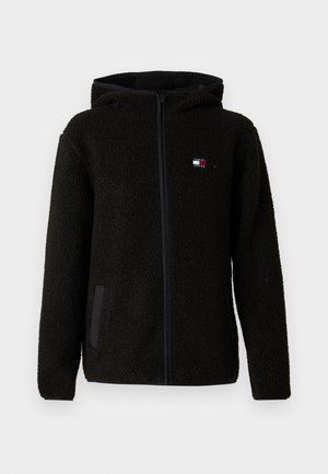 Svart fleece hettegenser med teksturert stoff, frontlukking, sidelommer og en liten logo på brystet. Har en avslappet passform og hette.