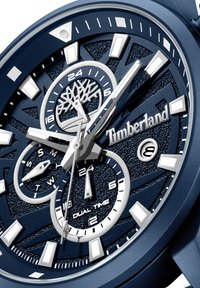 Orologio Timberland blu navy con quadrante testurizzato, funzione di doppio fuso orario, indicatori delle ore argentati e logo prominente. Diversi sottocampi messi in evidenza.
