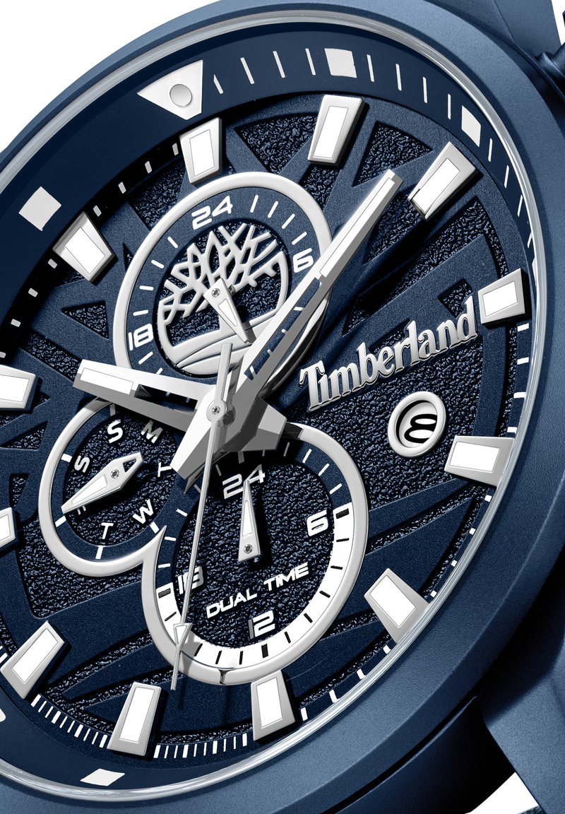 Dunkelblaue Timberland-Uhr mit strukturiertem Zifferblatt, Dual-Zeit-Funktion, silbernen Stundenmarkierungen und prominenten Logo. Mehrere hervorgehobene Unterzifferblätter.