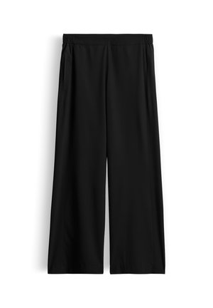 Zwarte broek met wijde pijpen, elastische tailleband en zijzakken, plat liggend tegen een witte achtergrond.