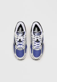 Blue mesh sneakers with white and black accents. Features a padded tongue, lace-up closure, and textured sole for grip.