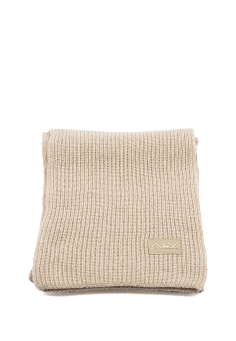 Sciarpa beige a coste realizzata in materiale morbido, con una piccola etichetta rettangolare color cuoio con testo in rilievo nell'angolo.