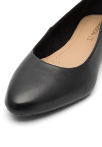 Černé baletky vyrobené z texturované syntetické kůže, s špičatou špičkou a hladkým vnitřním podšíváním. Jemné prošívání na stélce.