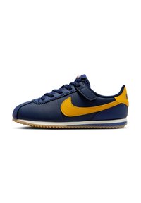 Baskets en cuir bleu marine avec un swoosh jaune, surface texturée et semelle en caoutchouc. Comprend des lacets et une sangle à boucle velcro.
