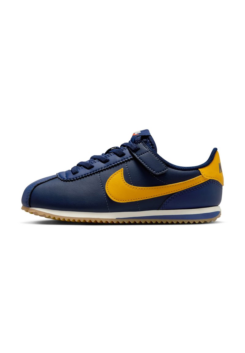 Baskets en cuir bleu marine avec un swoosh jaune, surface texturée et semelle en caoutchouc. Comprend des lacets et une sangle à boucle velcro.