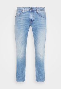 Vaqueros de un azul claro con un aspecto desgastado, con un diseño clásico de cinco bolsillos y cierre de botón, exhibidos sobre un fondo blanco.