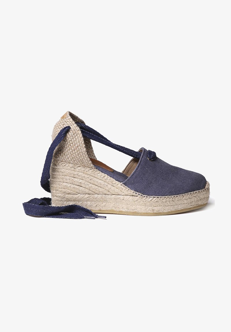 Marine canvas espadrille met een geweven jute hak, voorzien van gekruiste enkelbandjes en een ronde neus. Glad textuur met een natuurlijke afwerking.