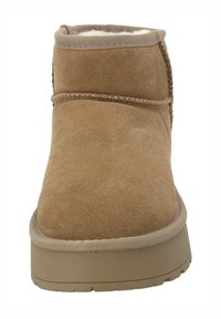 Bottines en suède marron avec une doublure douce, un haut arrondi, des coutures contrastées et une semelle en caoutchouc. Design minimaliste sans motifs.