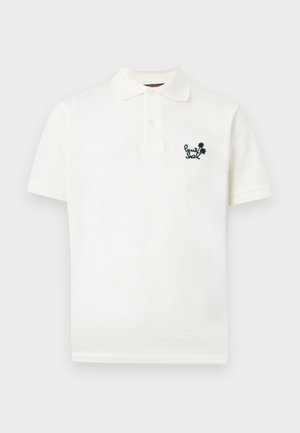 Polo blanco de manga corta con tapeta de dos botones y pequeño logo bordado en negro con texto y palmeras en el lado izquierdo del pecho.