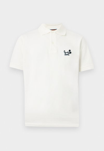 Λευκό πόλο με κοντά μανίκια, δύο κουμπιά στη λαιμόκοψη και μικρό μαύρο κεντητό λογότυπο με κείμενο και φοίνικες στο αριστερό στήθος.